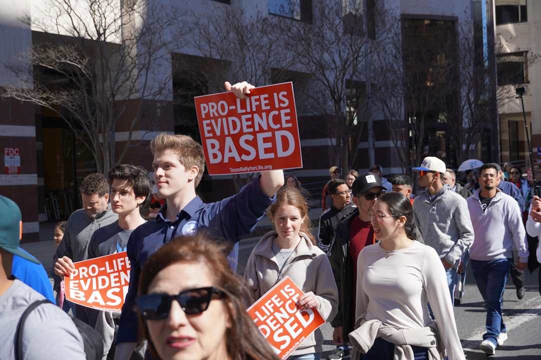 A group of people walking down a street holding signs