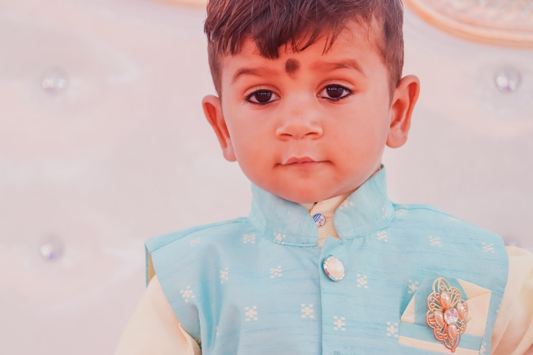 a young boy wearing a blue and white outfit