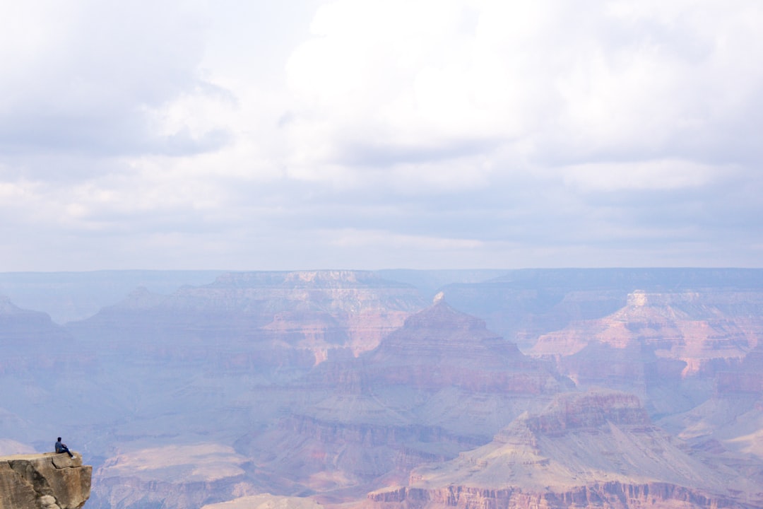 a man standing on a cliff overlooking a large canyon